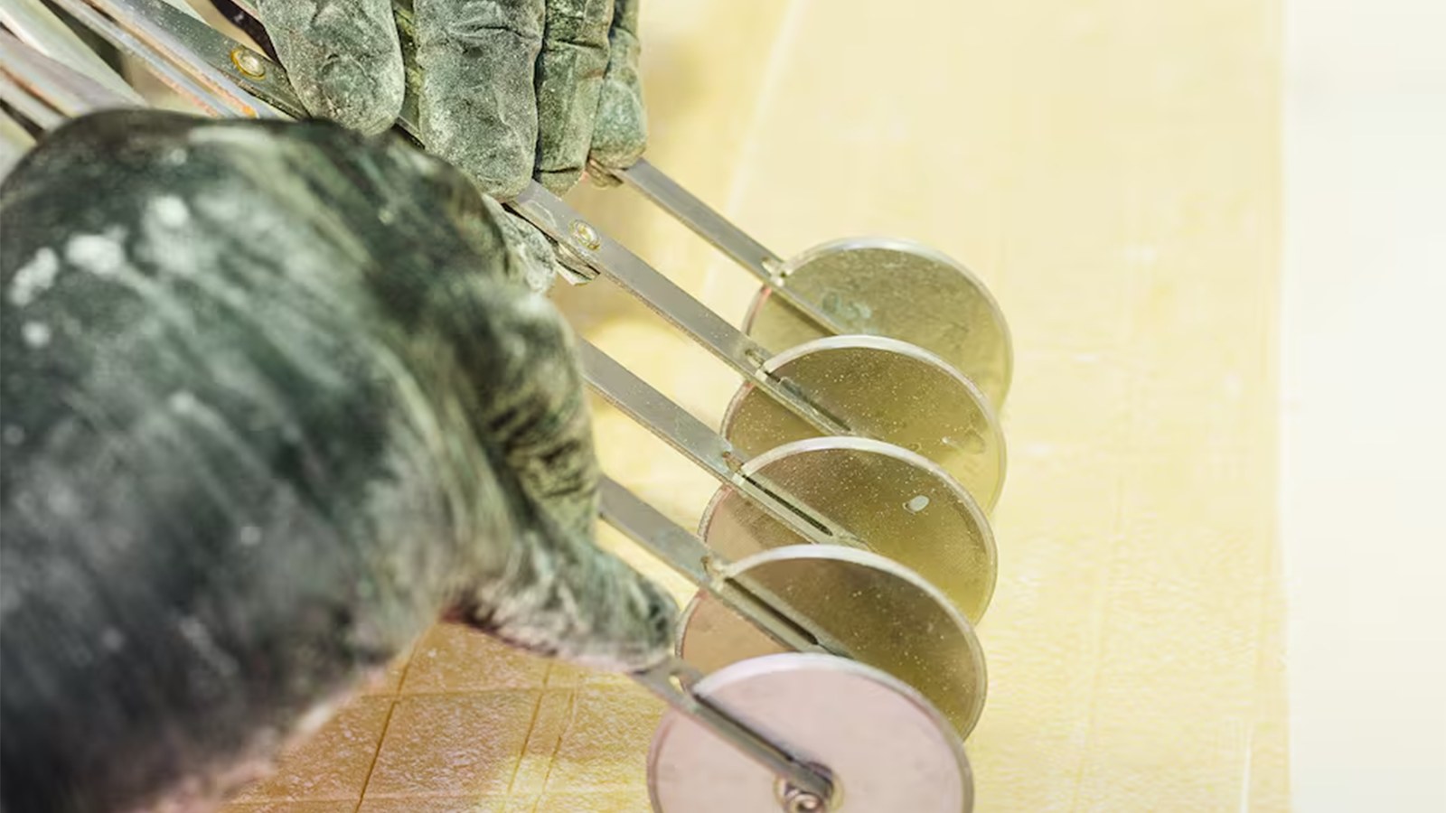 Chef che taglia fettuccine fresche fatte a mano durante la lezione di cucina italiana