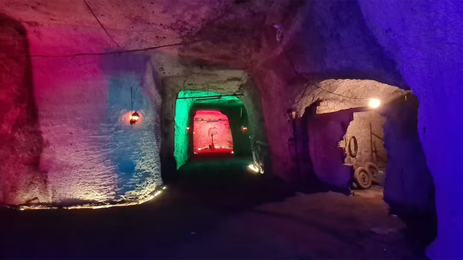 Cunicoli sotterranei del labirinto di Roma illuminati da torce durante il tour guidato